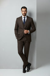 Man wearing brown slim fit three-piece suit with matching vest and tie.